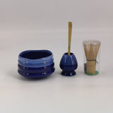 Blue matcha bowl with bamboo scoop resting in the whisk holder